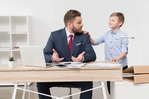 Niño travieso con su padre hombre de negocios - foto de stock