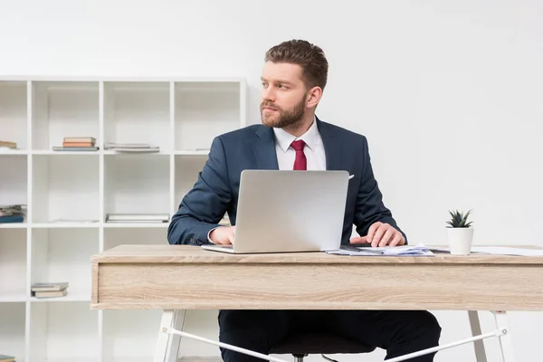 Confident businessman at table in office — Stock Photo