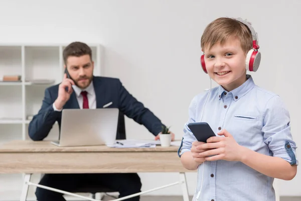 Entrepreneur au bureau avec son fils — Photo de stock