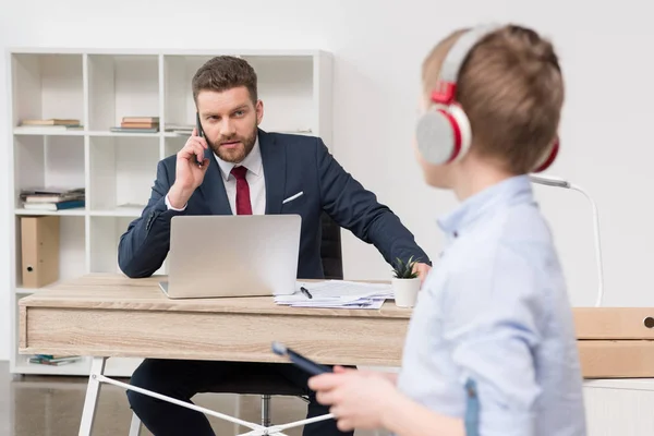 Empresario en la oficina con su hijo - foto de stock