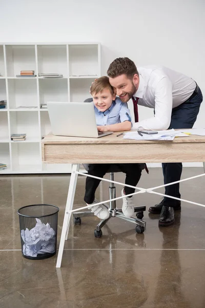 Empresário jogando no laptop com filho — Fotografia de Stock