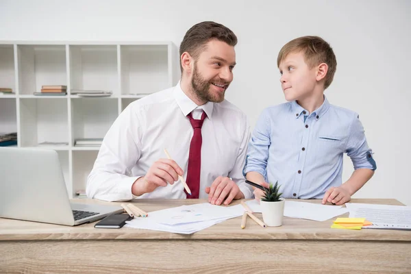 Businessman with son in office — Stock Photo