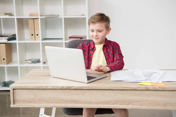 Écolier en utilisant ordinateur portable au bureau — Photo de stock