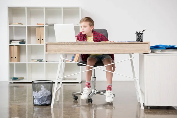 Schoolboy using laptop at office — Stock Photo