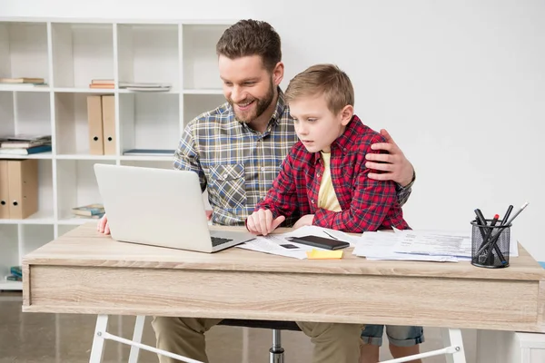 Freelancer trabalhando à mesa com filho — Fotografia de Stock