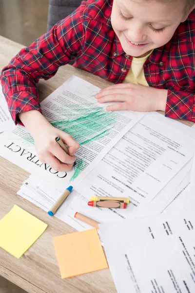 Naughty boy drawing on business papers — Stock Photo