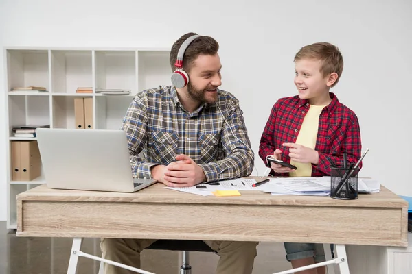 Empresario en auriculares con hijo - foto de stock