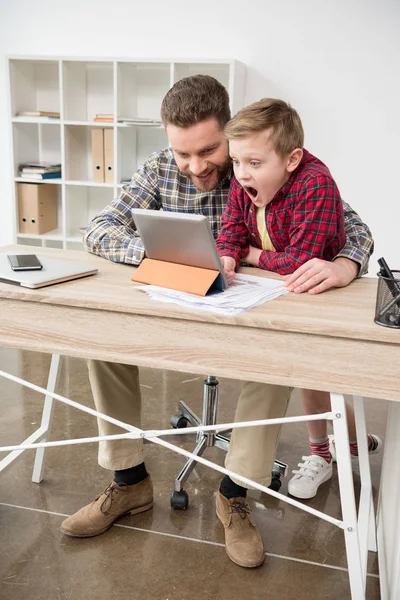 Businessman using tablet with son — Stock Photo