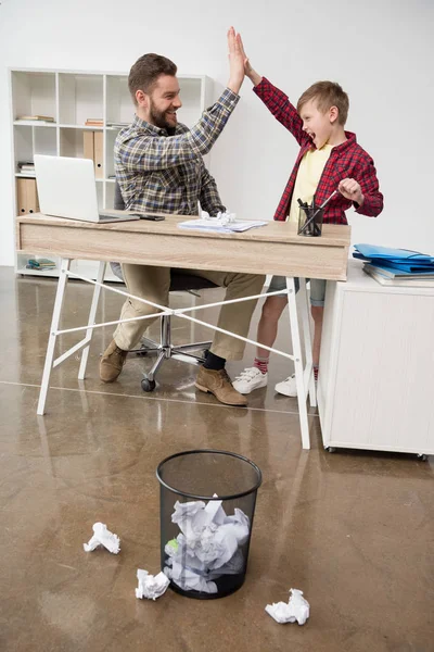 Businessman playing trashketball with son — Stock Photo