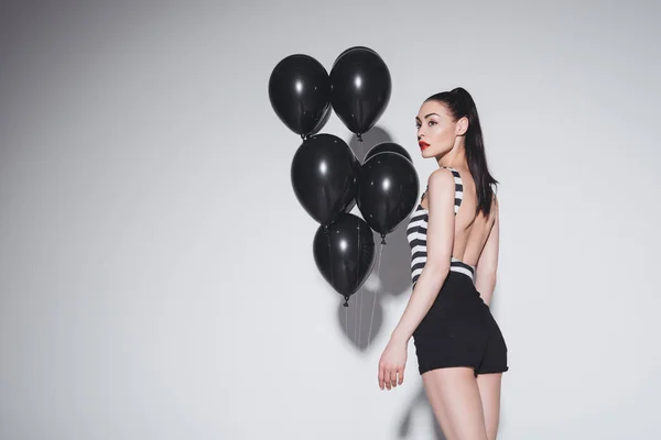 Mulher elegante com balões pretos — Fotografia de Stock