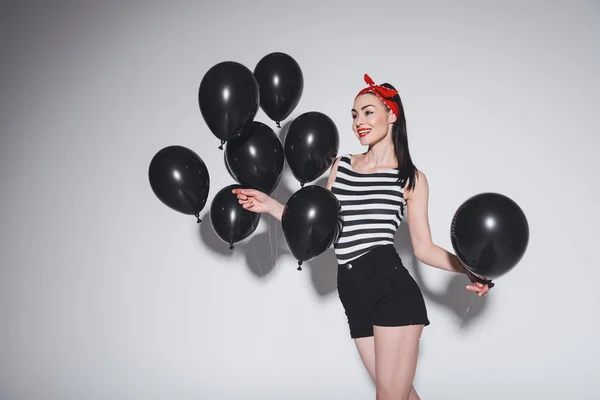 Femme élégante avec des ballons noirs — Photo de stock