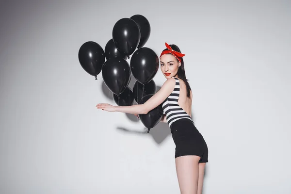 Stylische Frau mit schwarzen Luftballons — Stockfoto