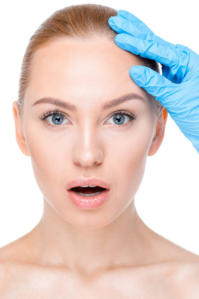 косметолог, осматривающий лицо пациента
