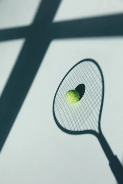 Tennis racket and ball on floor — Free Stock Photo