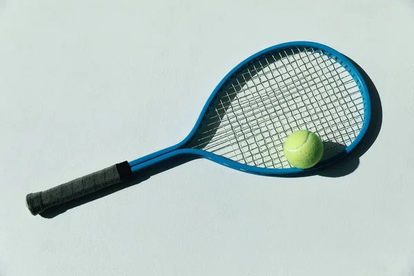 Tennis racket and ball on floor — Stock Photo, Image