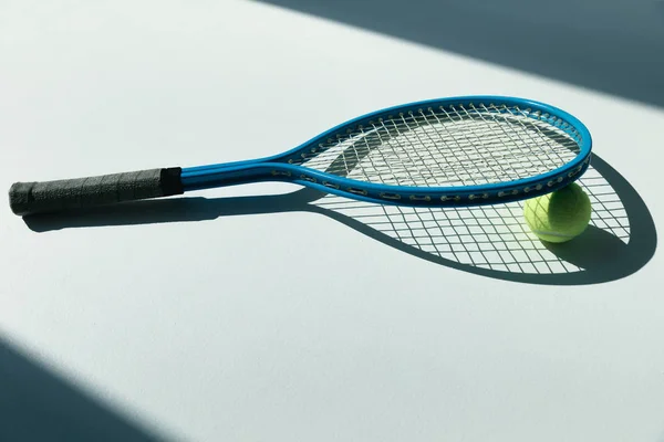 Tennis racket and ball on floor — Stock Photo, Image