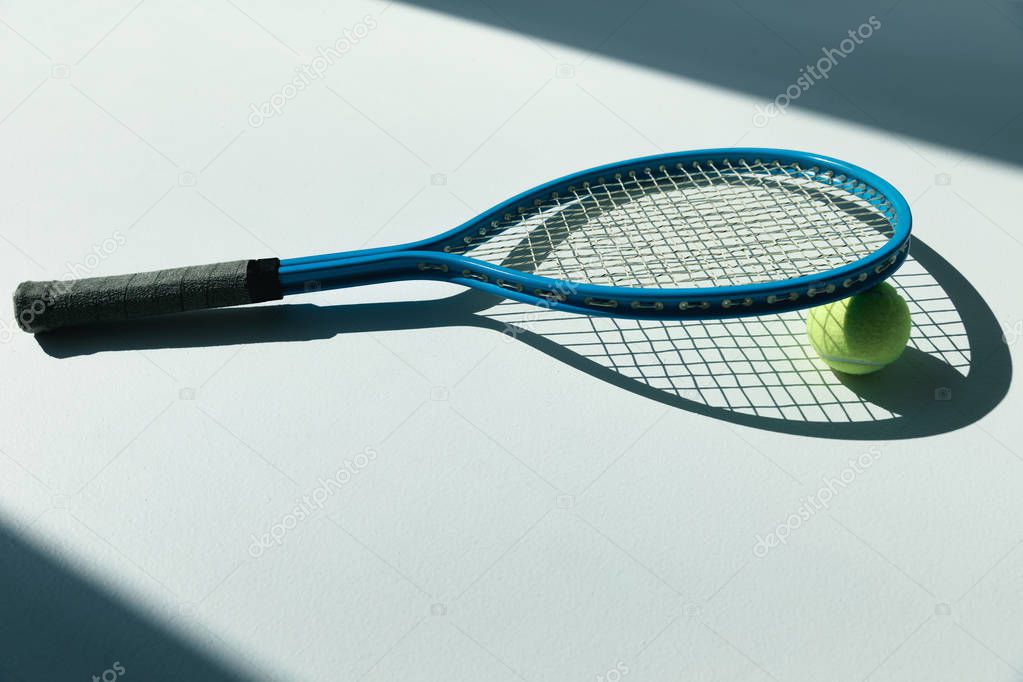 tennis racket and ball on floor 