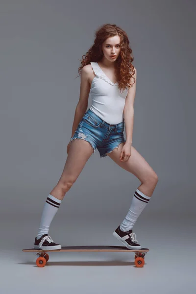 Stylish young woman with skateboard — Stock Photo, Image