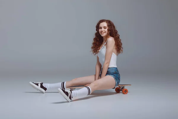 Elegante giovane donna con skateboard — Foto Stock
