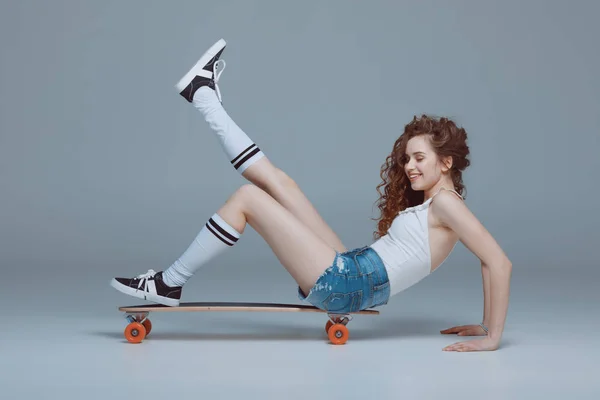 Stylish young woman with skateboard — Stock Photo, Image