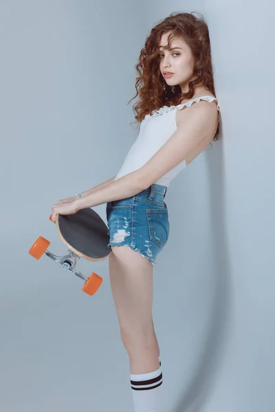 Хипстерская девушка со скейтбордом — стоковое фото