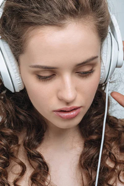 Kvinde lytter musik i hovedtelefoner - Stock-foto