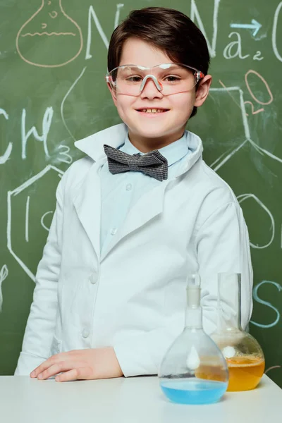 Niño con bata de laboratorio y gafas protectoras — Foto de Stock