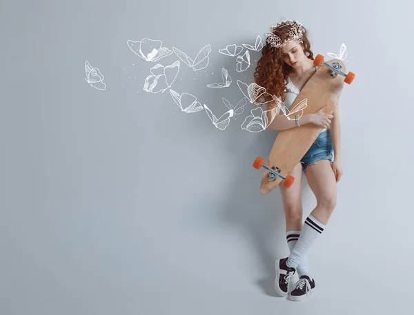 Redhead girl with butterflies and longboard