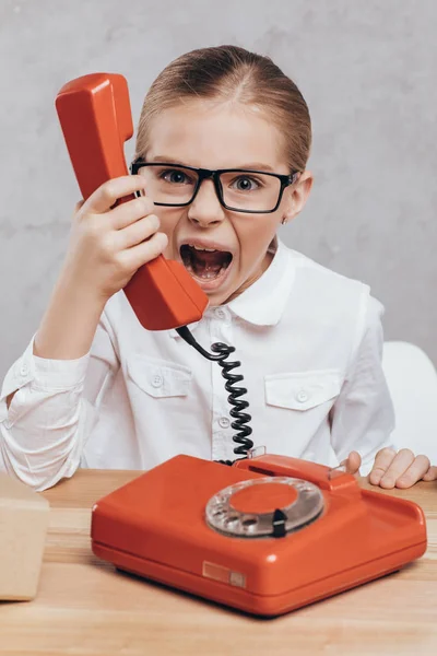 Screaming child with telephone — Free Stock Photo