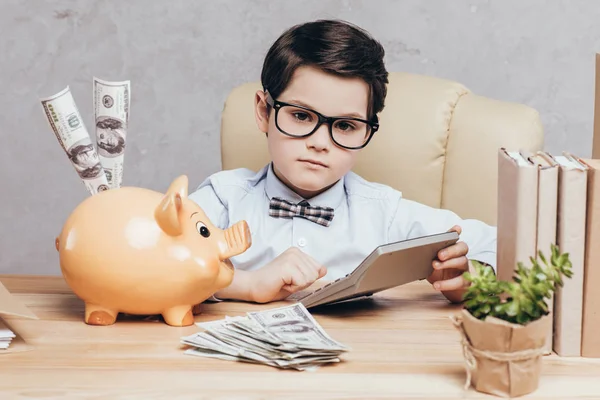 Kid using calculator at workplace — Stock Photo, Image