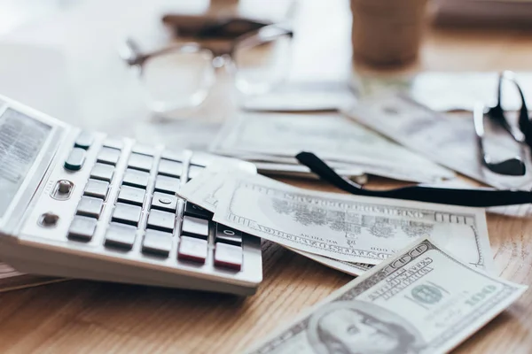 Dinheiro e calculadora no local de trabalho — Fotografia de Stock