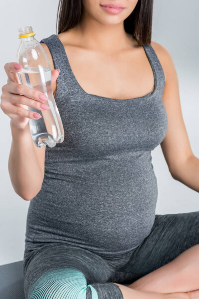 Беременная женщина с бутылкой воды
