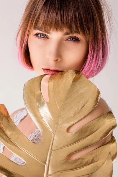 Mujer posando con hoja de palma dorada — Foto de Stock