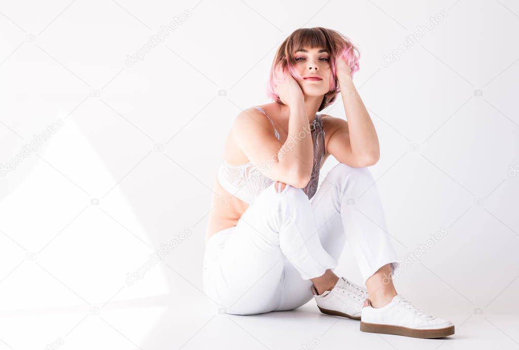 woman with pink hair sitting on floor