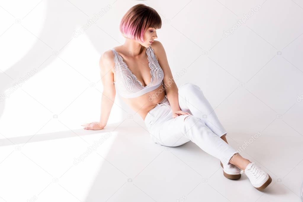 woman with pink hair posing on floor