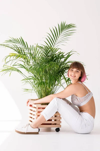 Woman hugging flowerpot with plant — Stock Photo, Image