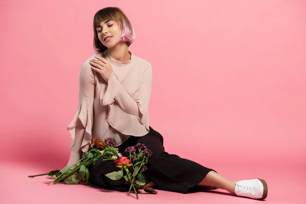 Jeune femme assise sur le sol avec bouquet — Photo