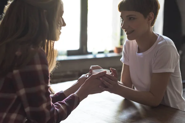 Jonge Lesbische Paar Kopje Koffie Bij Elkaar Houden Glimlachen — Stockfoto