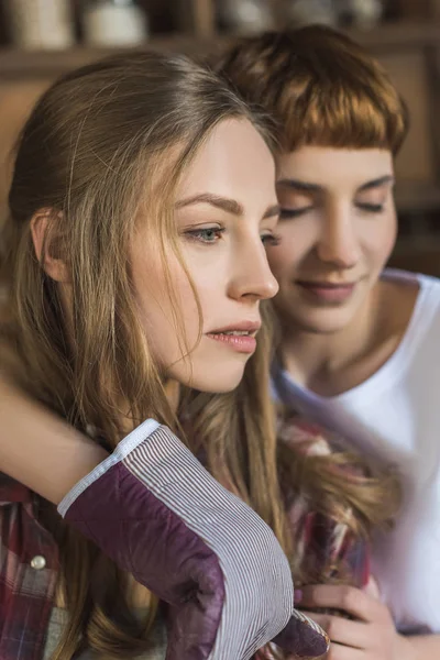 Joven Lesbiana Con Guante Horno Abrazando Novia Por Detrás Imagen de archivo