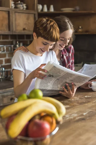 Junges Lesbisches Paar Liest Gemeinsam Zeitung Der Küche Stockbild