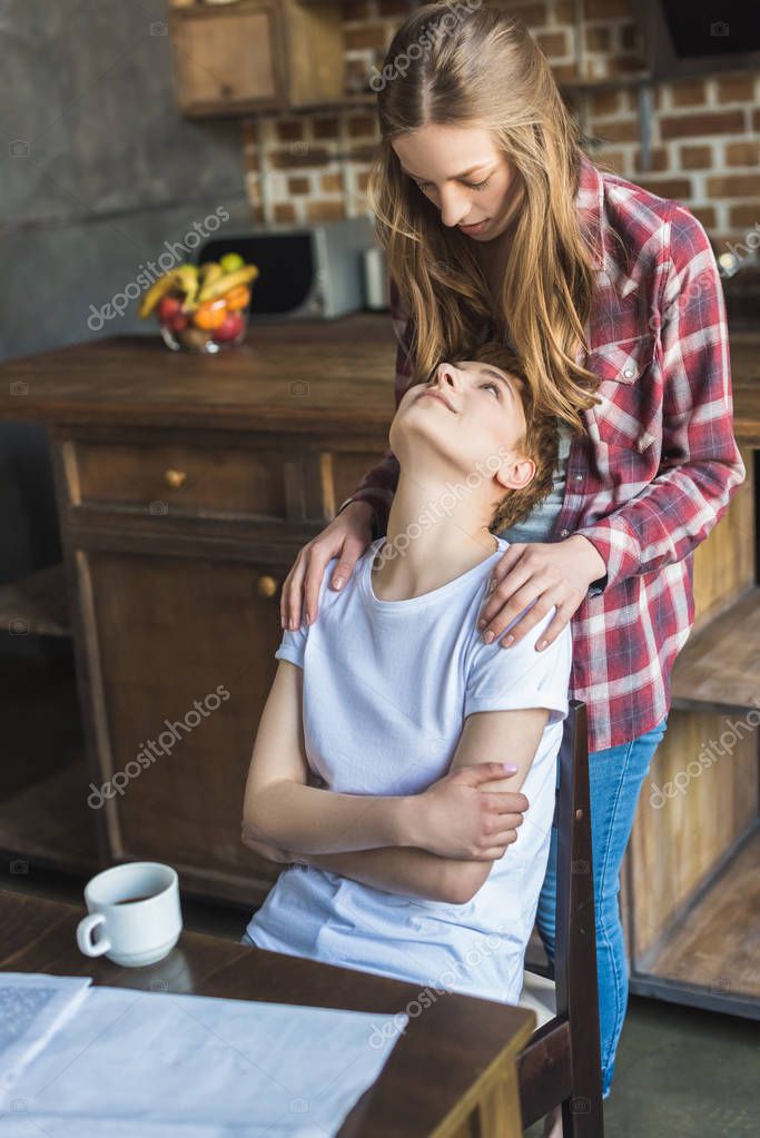 Beautiful young lesbian couple spending time together on kitchen in morning