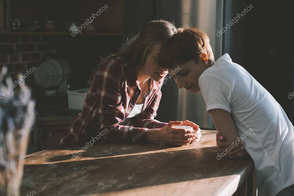 Young lesbian couple spending time together on kitchen in morning