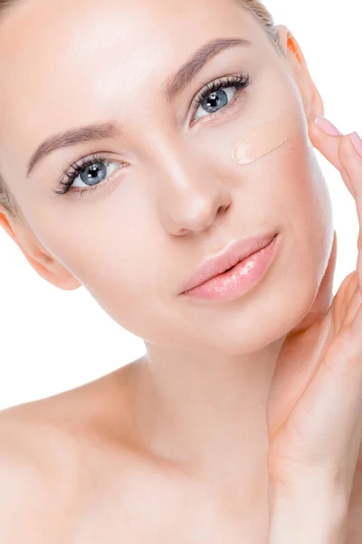 Mujer con crema de fundación en la cara - foto de stock