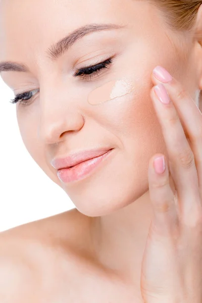 Mujer con crema de fundación en la cara - foto de stock