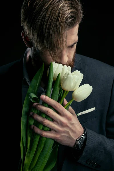 Elegante hombre de negocios con tulipanes - foto de stock