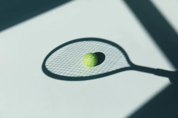 Tennis racket and ball on floor — Stock Photo