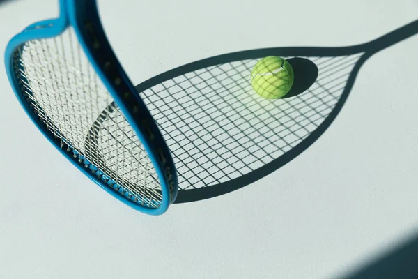 Tennis racket and ball on floor — Stock Photo