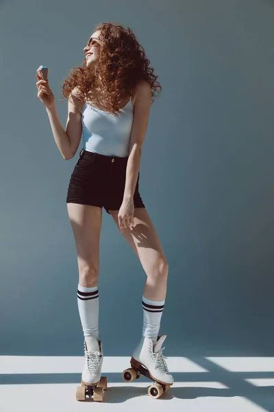 Chica en rodillos comer helado - foto de stock