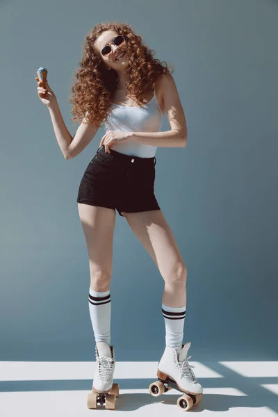 Chica en rodillos comer helado - foto de stock