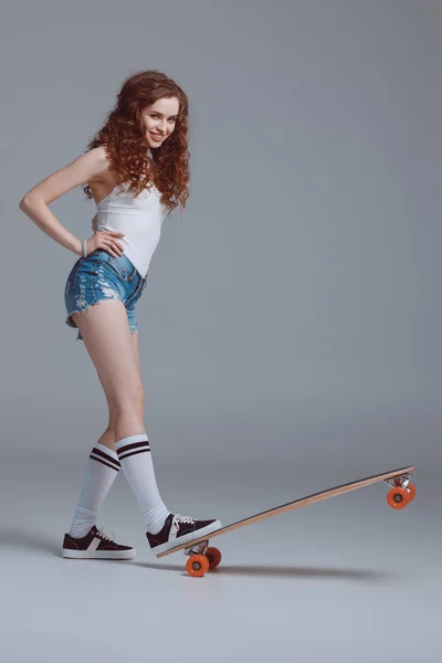 Jeune femme élégante avec skateboard — Photo de stock